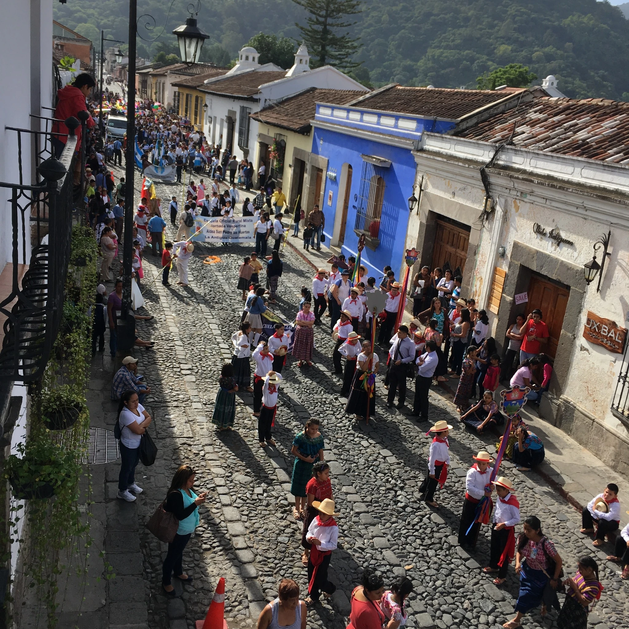Desfile comunitario por una calle empedrada de Antigua Guatemala