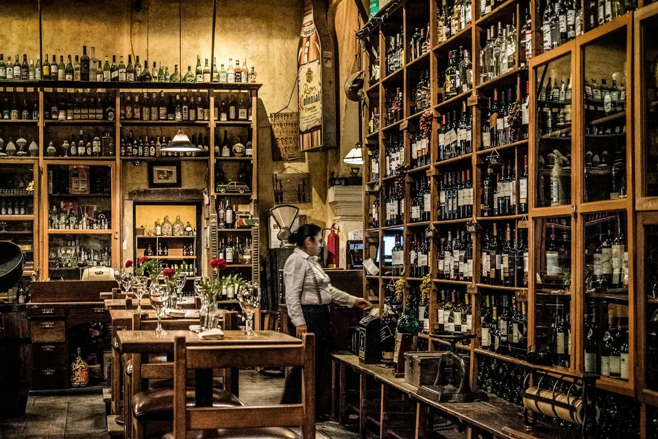 Mesas, estanterías de vino y personal en El Sabor del Tiempo, Antigua Guatemala.